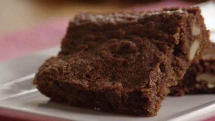 Two brownie squares on a white plate.